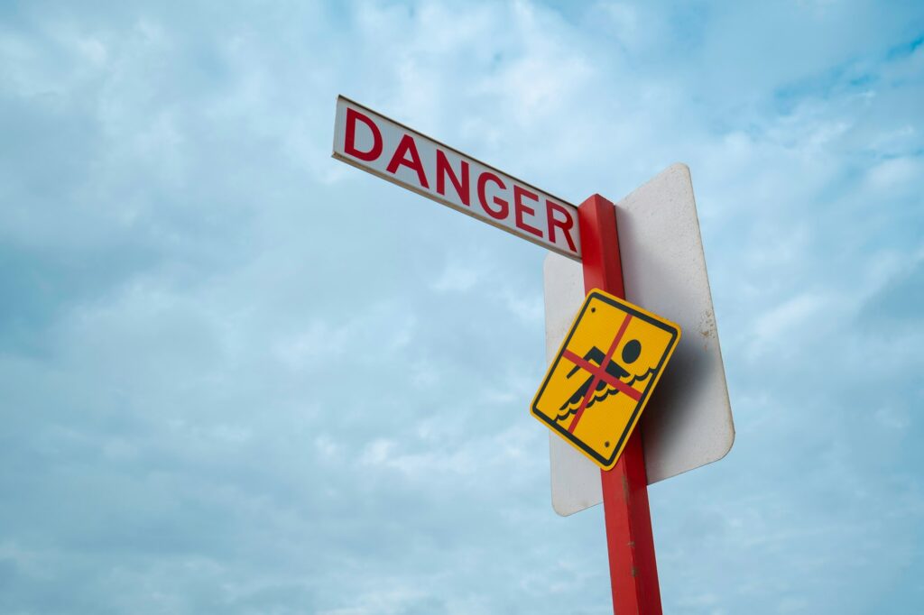 "Danger" sign at beach, warning swimmers to not swim in this area of the beach